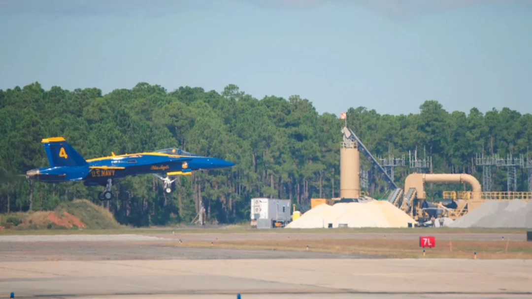 Navy jet taking off from a concrete airfield